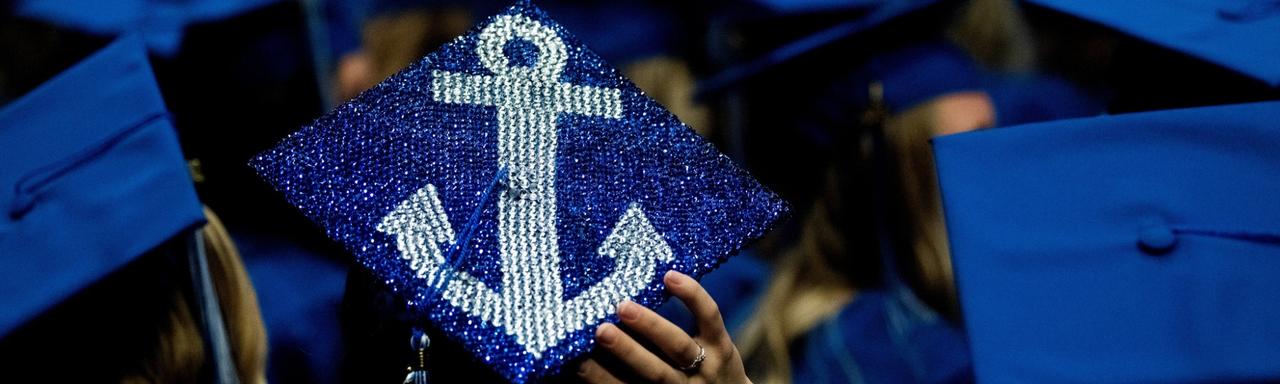 Four grads smile for a photo at Commencement